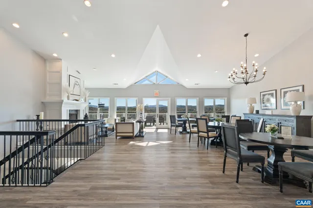 a kitchen with stainless steel appliances kitchen island granite countertop a dining table chairs and a refrigerator