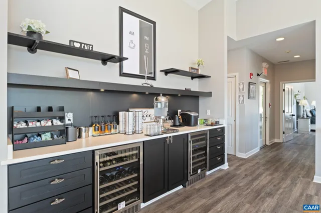a spacious bedroom with a bed a rug and wooden floor