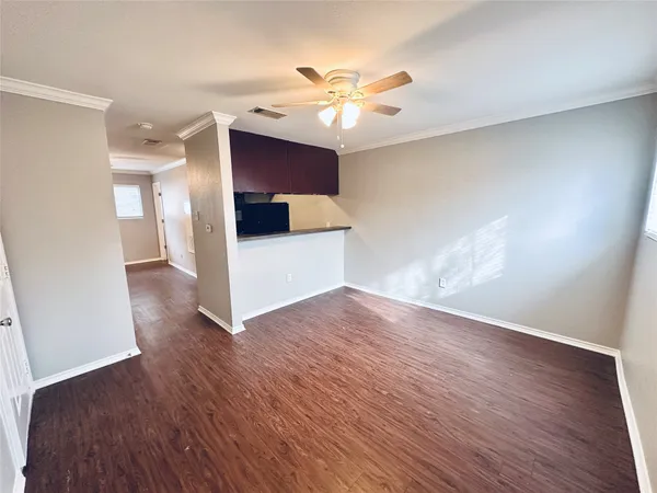 a view of a livingroom with a ceiling fan and wooden floor