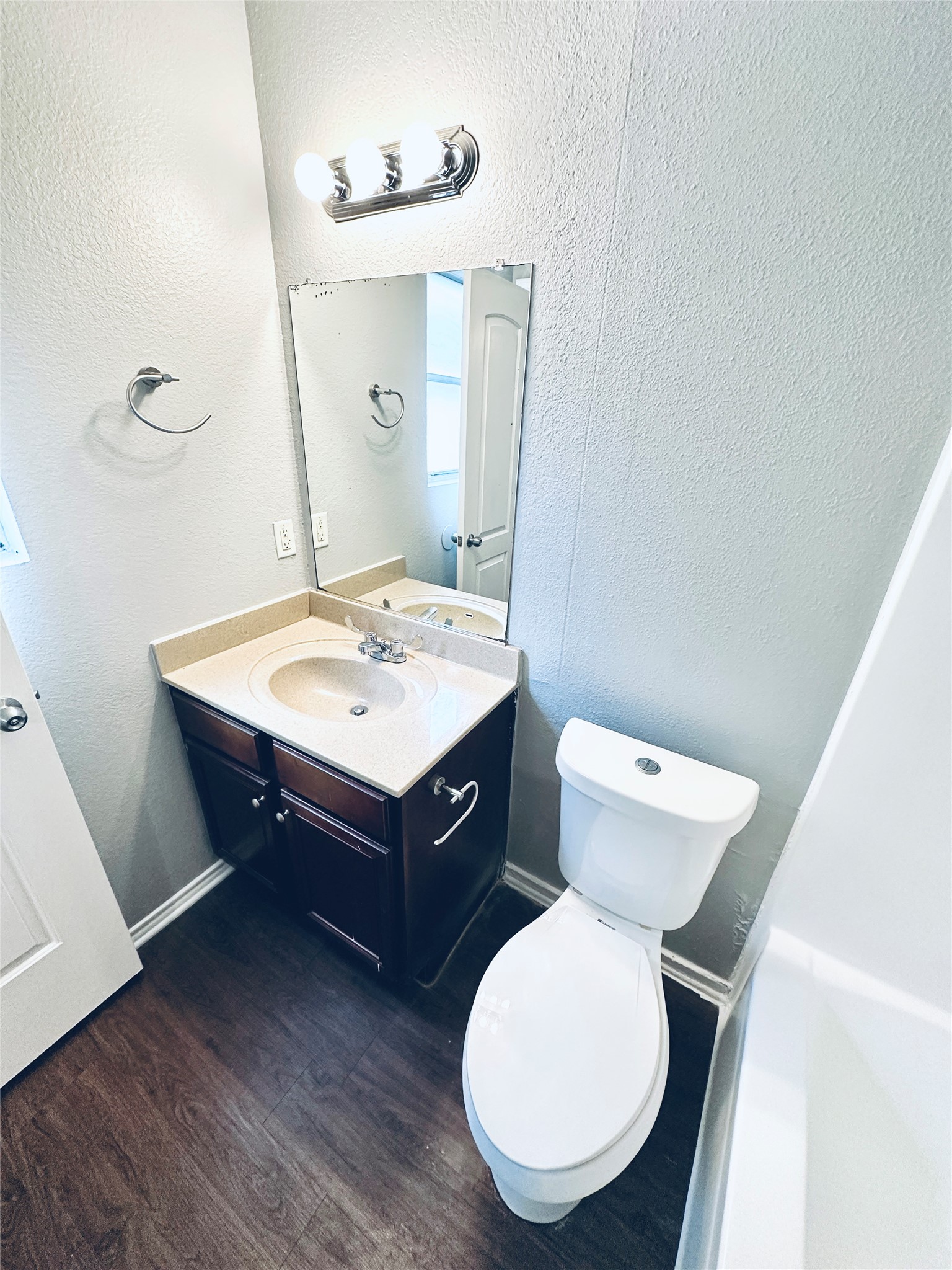 805 South Center Street, Unit 108 Austin, TX 78704 - Photo 13 of 14 Bathroom featuring a textured wall, vanity, and dark wood-style flooring