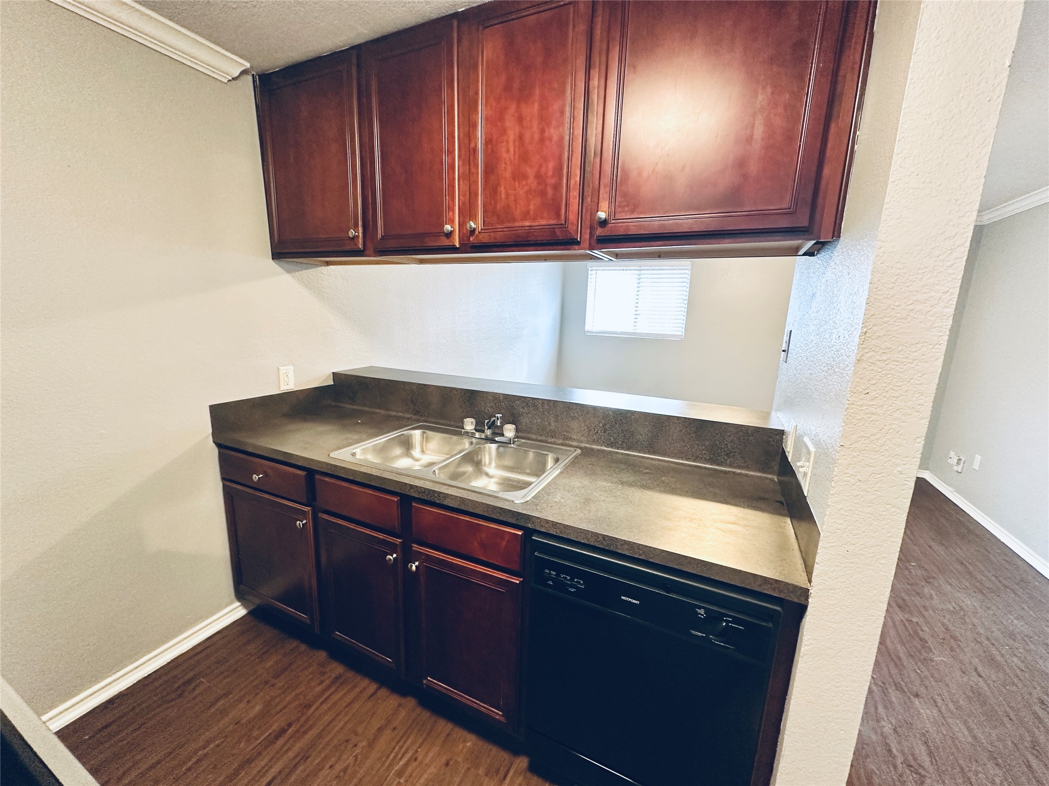 805 South Center Street, Unit 108 Austin, TX 78704 - Photo 5 of 14 Kitchen featuring dishwasher, dark wood-type flooring, crown molding, a textured wall, and bold wood finish cabinetry