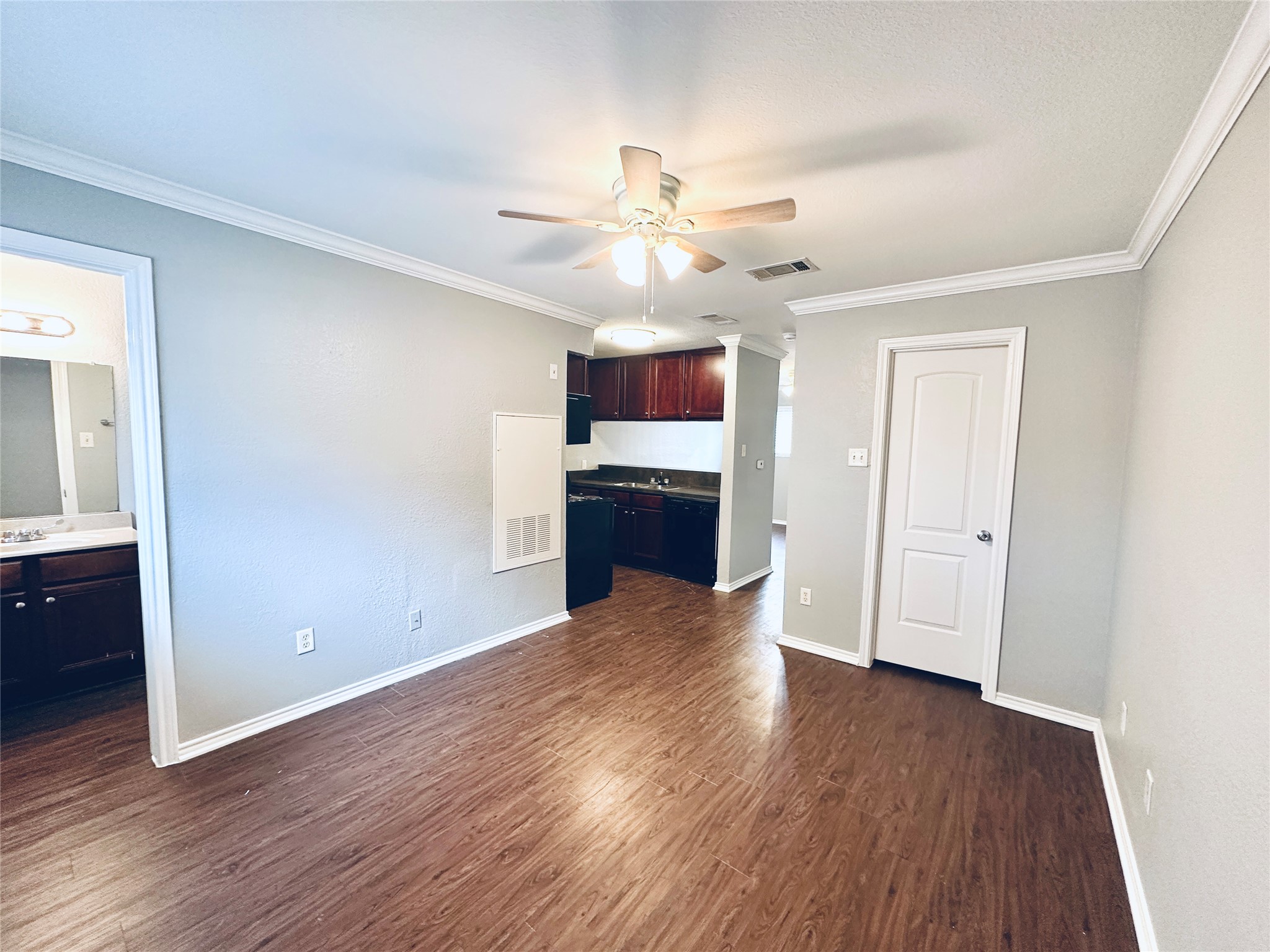 805 South Center Street, Unit 108 Austin, TX 78704 - Photo 9 of 14 Unfurnished living room featuring ceiling fan, crown molding, and dark wood finished floors