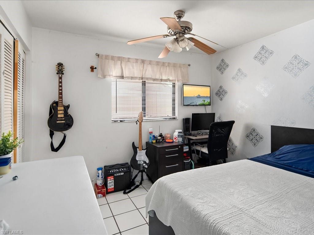 4865 22nd Avenue Southwest Naples, FL 34116 - Photo 12 of 20 a bedroom with a bed and a chandelier