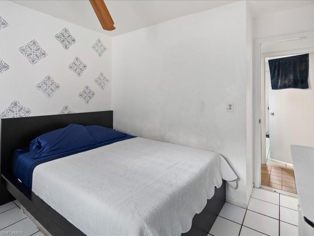 4865 22nd Avenue Southwest Naples, FL 34116 - Photo 13 of 20 a bedroom with a bed and cabinets