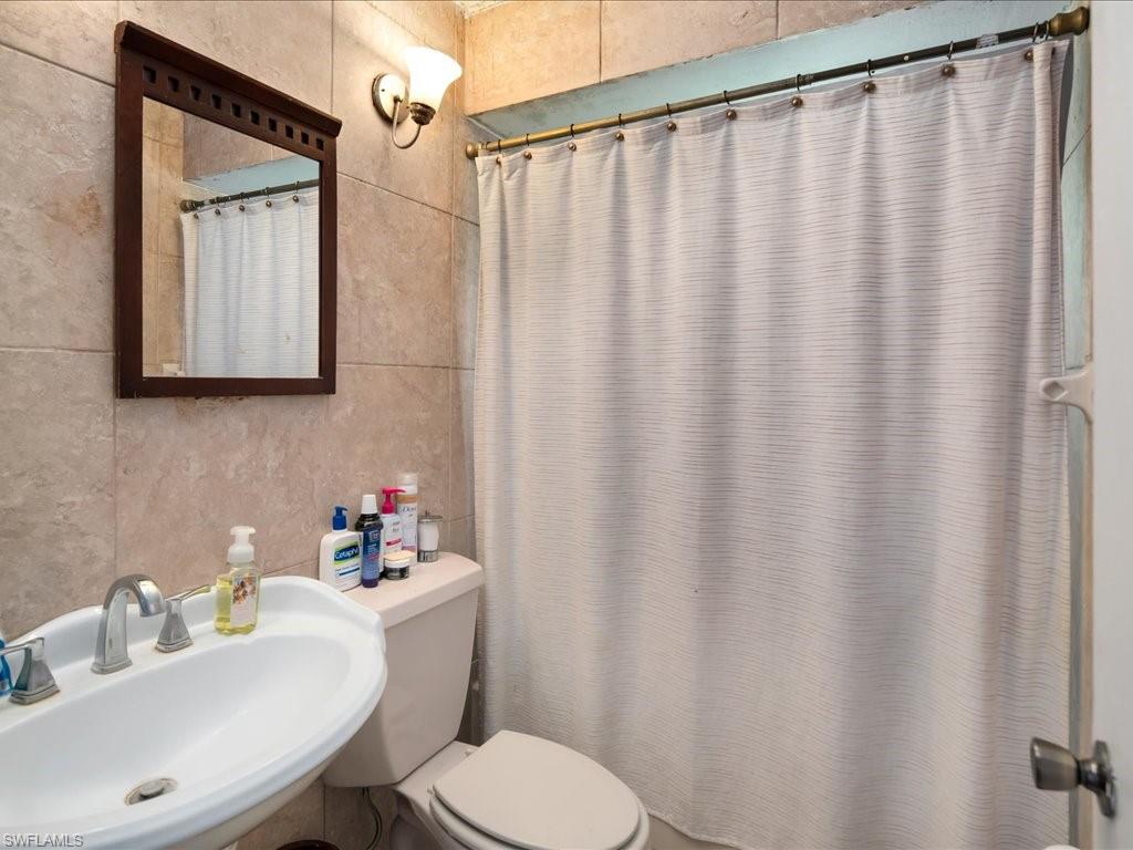 4865 22nd Avenue Southwest Naples, FL 34116 - Photo 15 of 20 a bathroom with a sink a toilet and a mirror