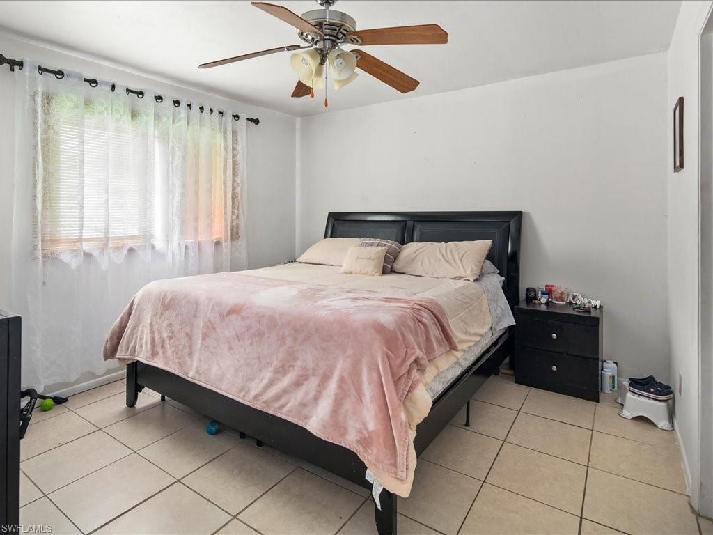 4865 22nd Avenue Southwest Naples, FL 34116 - Photo 10 of 20 a bedroom with a bed and a chandelier