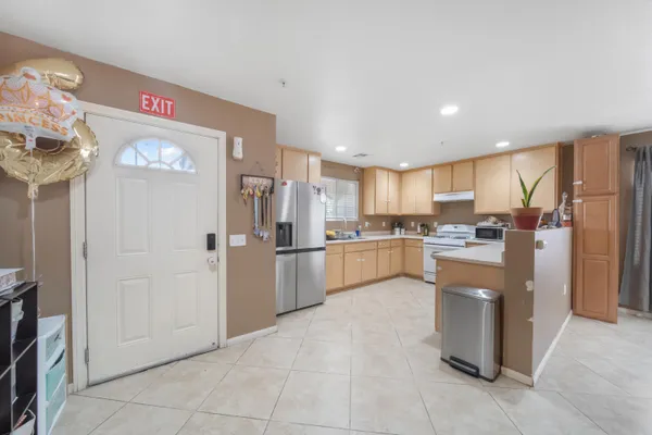 a kitchen with stainless steel appliances white cabinets sink and a window