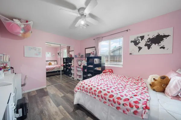 a bedroom with a bed a dresser and a large window