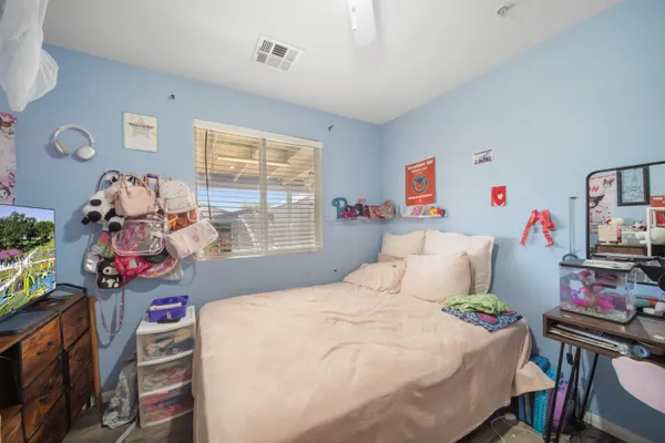 a bedroom with a bed dresser and flat screen tv