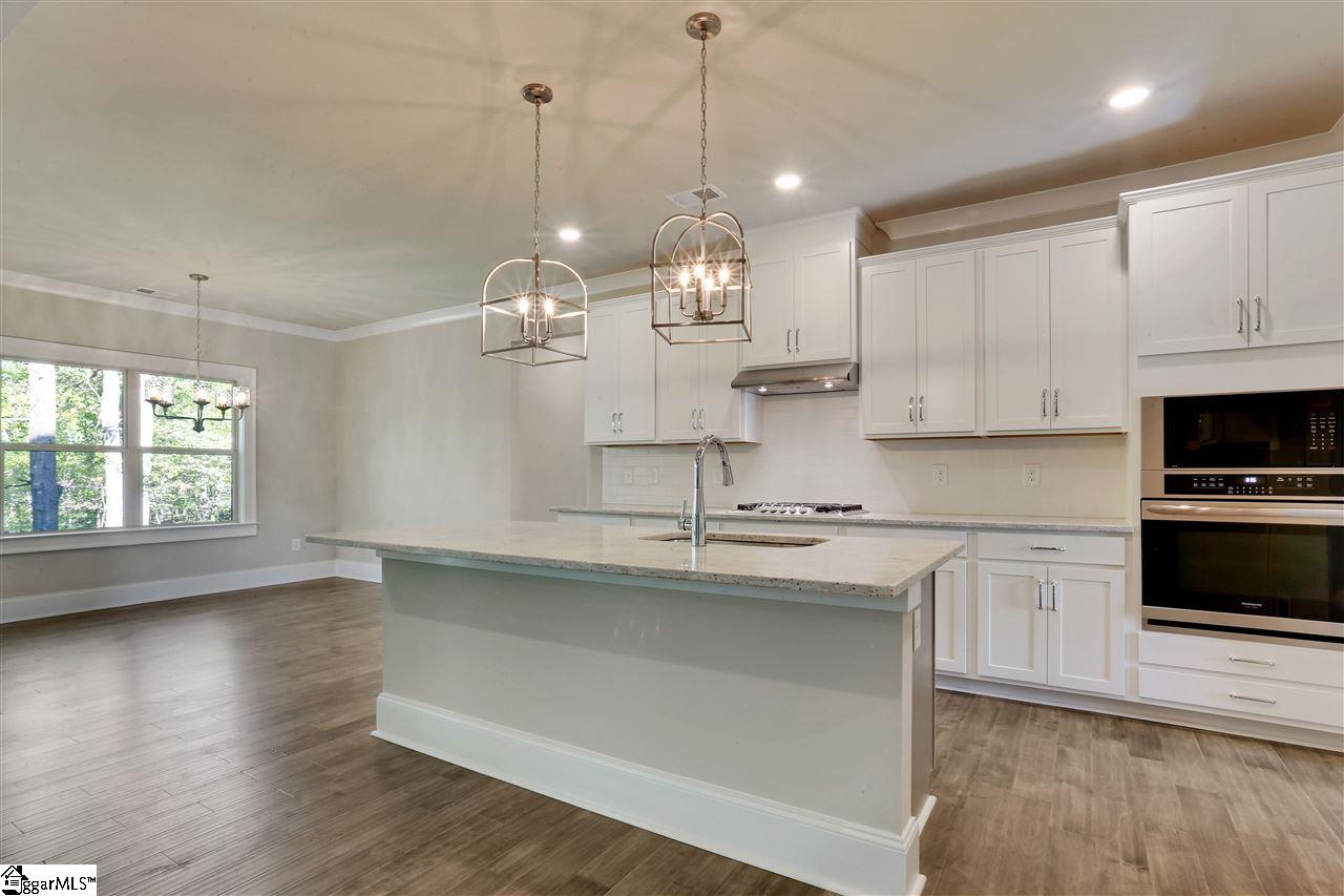 604 Rutland Court, Unit SITE 13 Greer, SC 29651 - Photo 8 of 33 Stainless built-in appliances with gas cooktop, granite counters, tile backsplash and 42" cabinets with crown molding! Large walk-in pantry steps away.