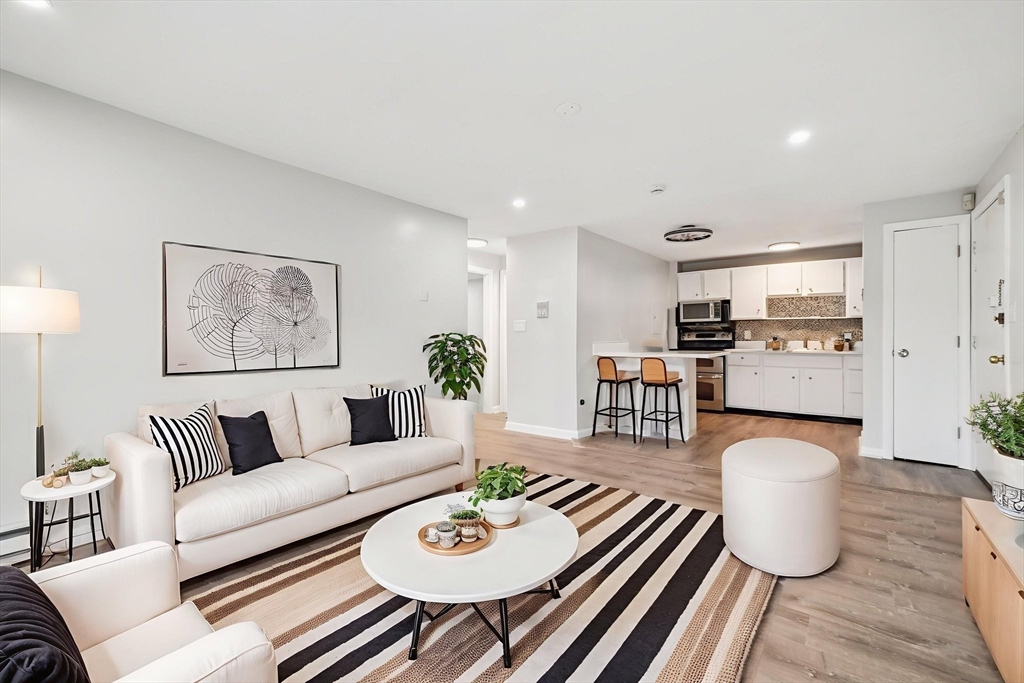 770 Cummins Highway, Unit 22 Boston, MA 02126 - Photo 1 of 28 a living room with furniture and a wooden floor