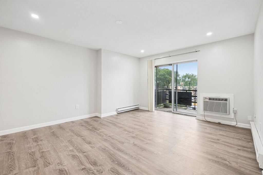 770 Cummins Highway, Unit 22 Boston, MA 02126 - Photo 13 of 28 a view of an empty room with wooden floor and a window