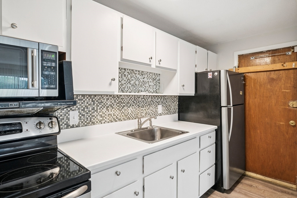 770 Cummins Highway, Unit 22 Boston, MA 02126 - Photo 15 of 28 a kitchen with a sink and a refrigerator