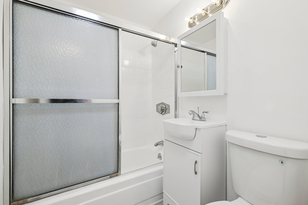 770 Cummins Highway, Unit 22 Boston, MA 02126 - Photo 16 of 28 a bathroom with a sink a toilet and shower