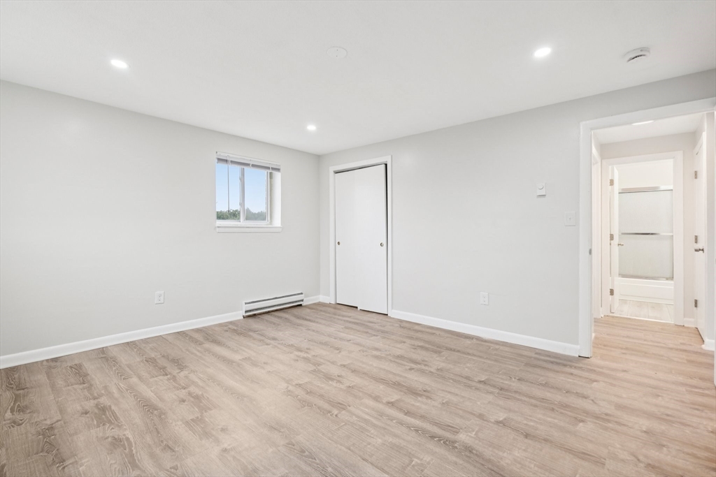 770 Cummins Highway, Unit 22 Boston, MA 02126 - Photo 8 of 28 a view of an empty room with wooden floor and a window