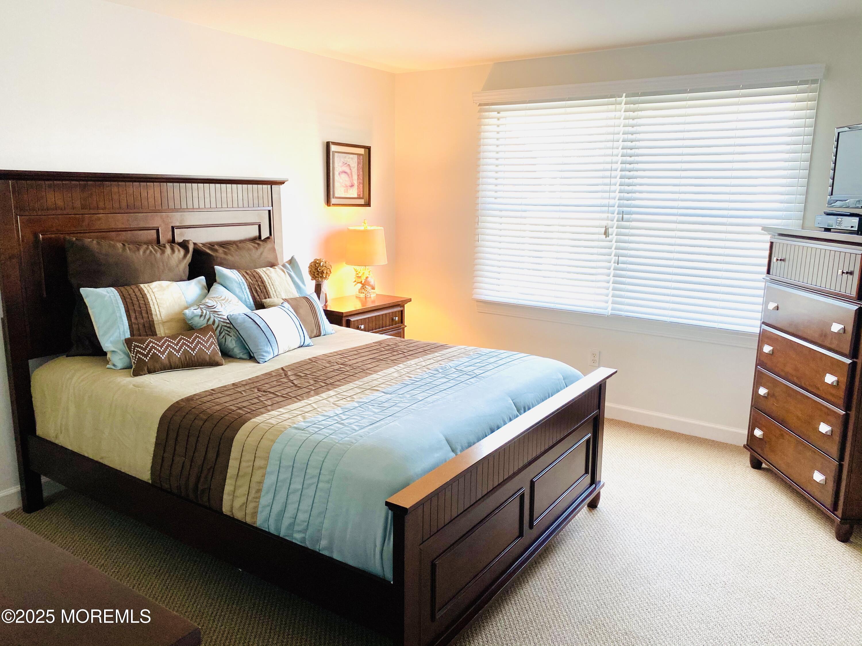 1926 Oceanfront, Unit 14 Seaside Heights, NJ 08751 - Photo 15 of 21 a bed sitting in a bedroom next to a window