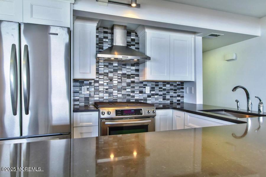 1926 Oceanfront, Unit 14 Seaside Heights, NJ 08751 - Photo 16 of 21 a kitchen with a sink and refrigerator
