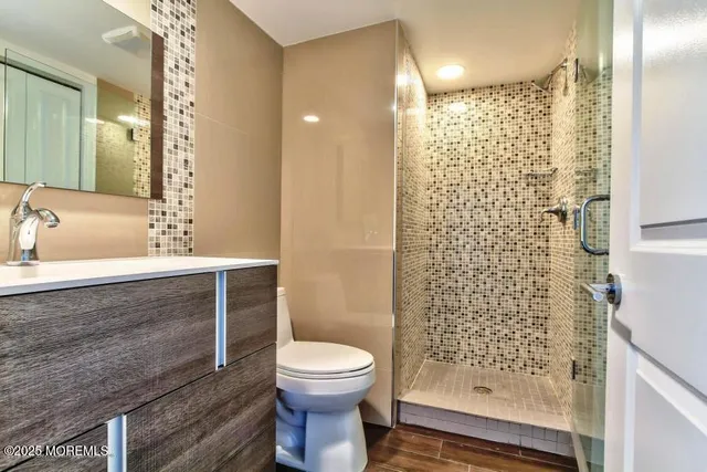 a bathroom with a sink a toilet and shower