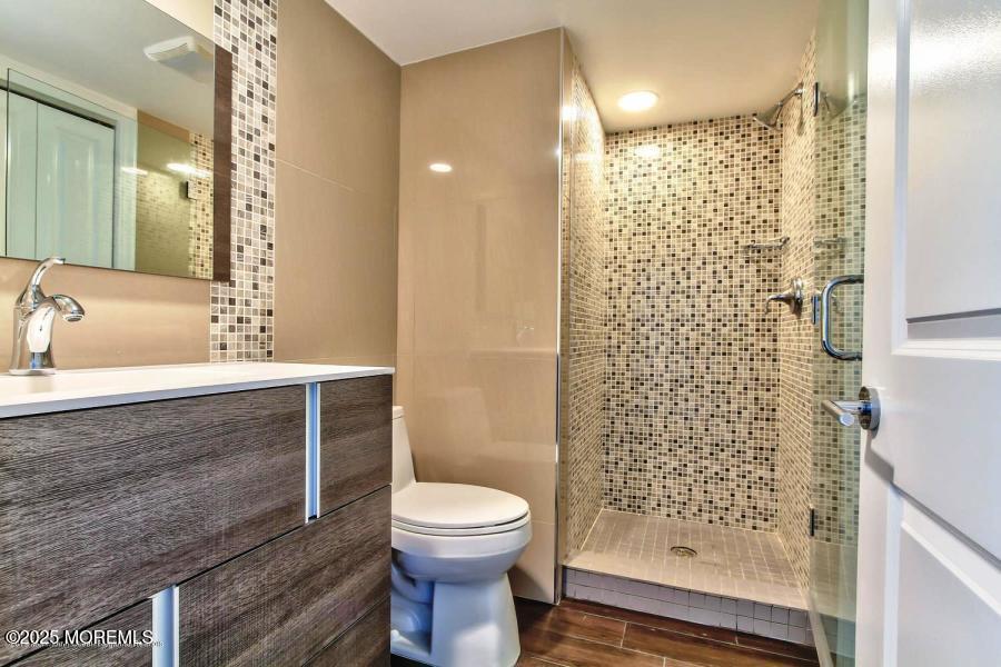1926 Oceanfront, Unit 14 Seaside Heights, NJ 08751 - Photo 18 of 21 a bathroom with a sink a toilet and shower