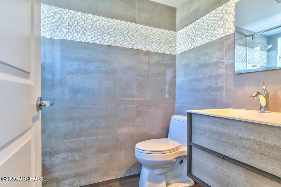 1926 Oceanfront, Unit 14 Seaside Heights, NJ 08751 - Photo 19 of 21 a bathroom with a sink a toilet and shower