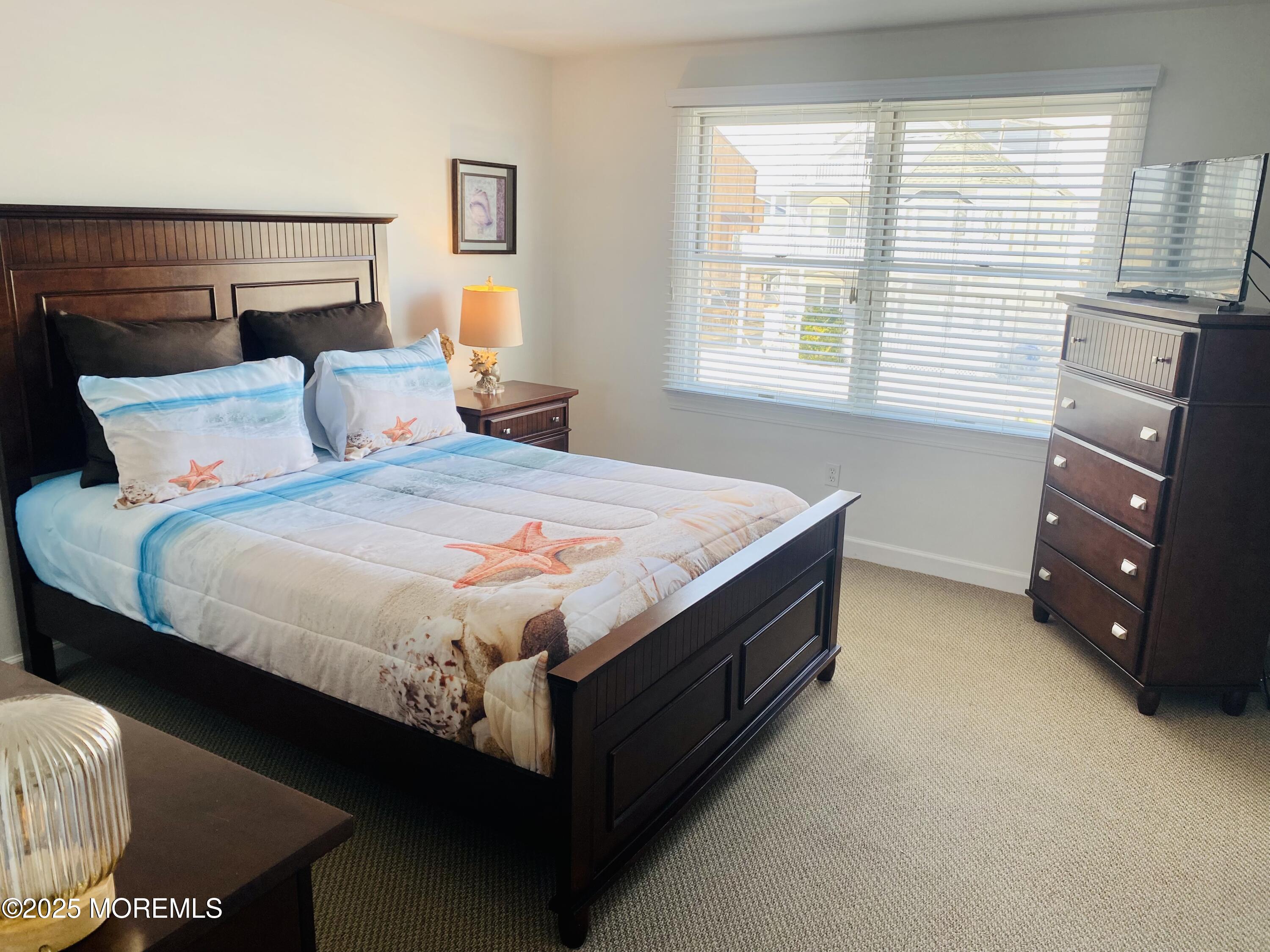 1926 Oceanfront, Unit 14 Seaside Heights, NJ 08751 - Photo 5 of 21 a bed sitting in a bedroom next to a window