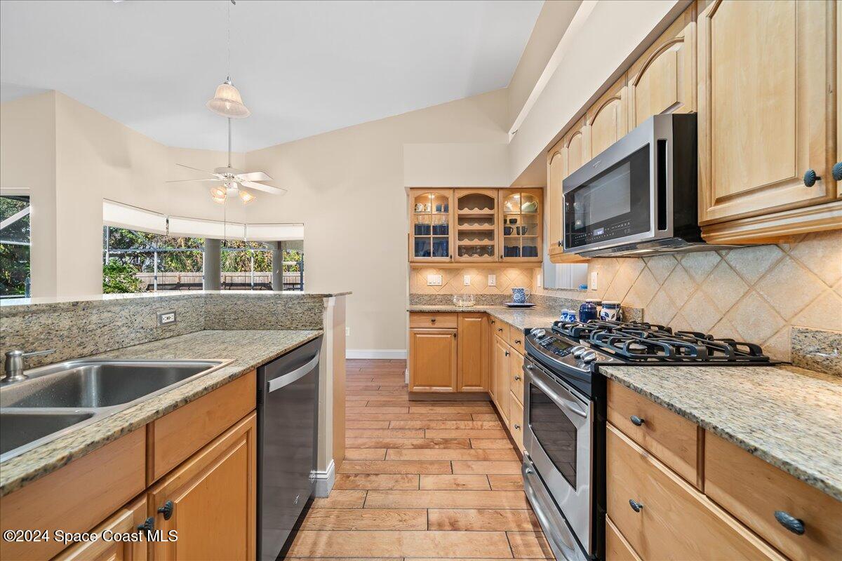 4360 Canard Road Melbourne, FL 32934 - Photo 16 of 54 a kitchen with stainless steel appliances granite countertop a sink and a stove