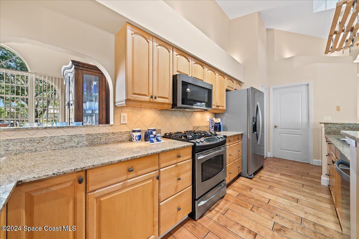 4360 Canard Road Melbourne, FL 32934 - Photo 17 of 54 a kitchen with stainless steel appliances granite countertop a stove a sink and a refrigerator