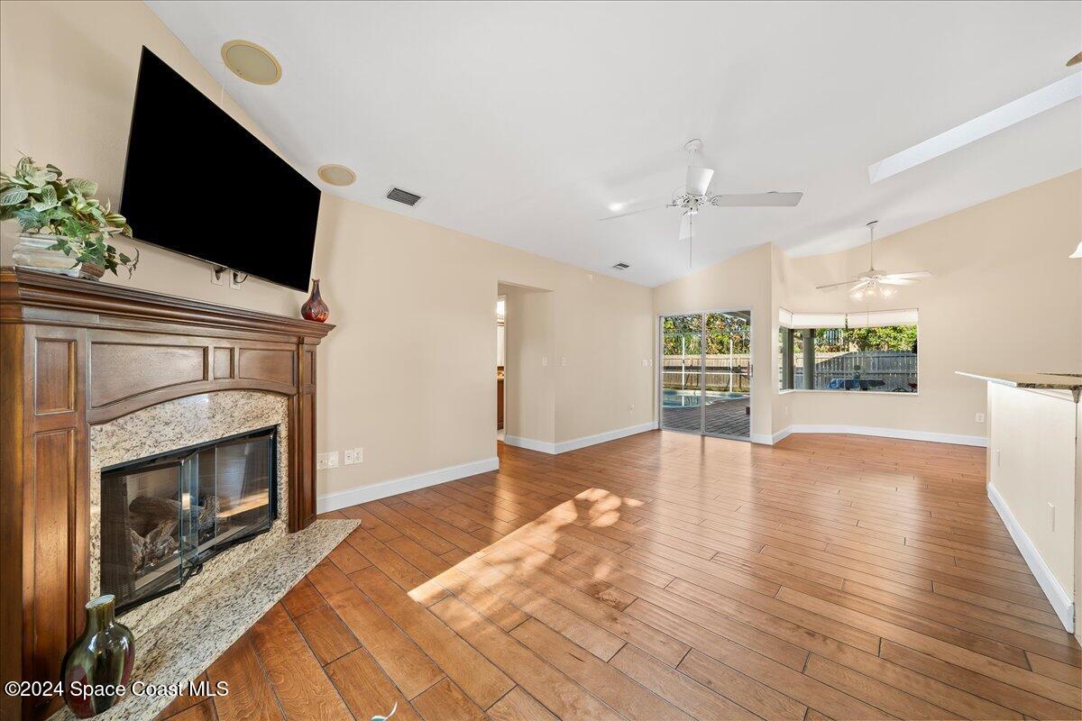 4360 Canard Road Melbourne, FL 32934 - Photo 19 of 54 a view of a livingroom with a fireplace a flat screen tv and staircase