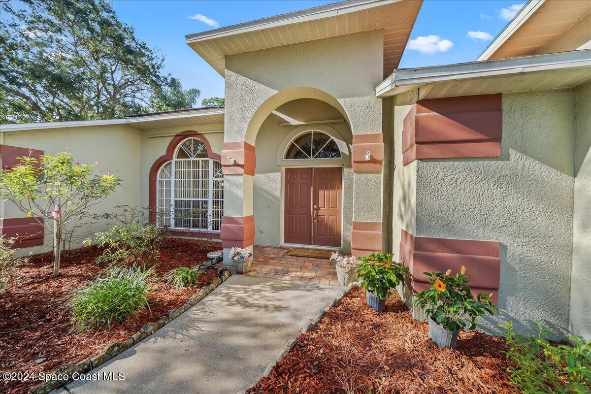 4360 Canard Road Melbourne, FL 32934 - Photo 3 of 54 a front view of a house with garden