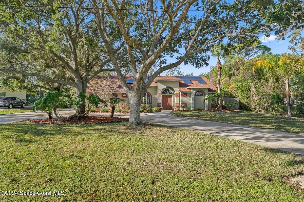 4360 Canard Road Melbourne, FL 32934 - Photo 44 of 54 a backyard of a house with large trees and outdoor seating