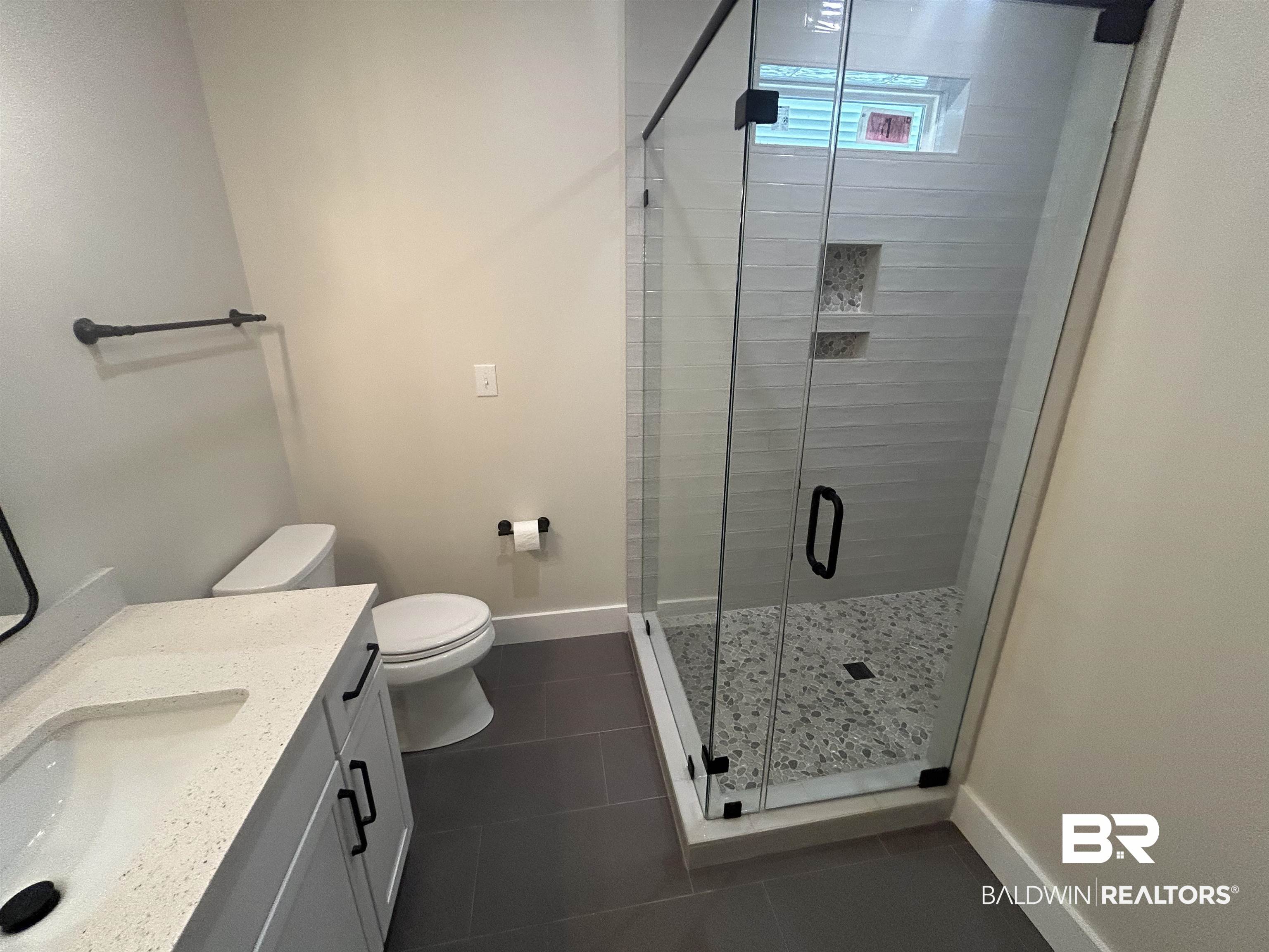 5122 Pine Road Orange Beach, AL 36561 - Photo 20 of 24 Bathroom with vanity, a shower stall, and dark tile patterned flooring