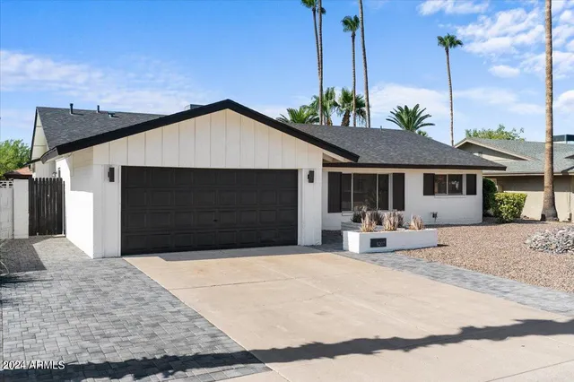 a front view of a house with yard and tress in it