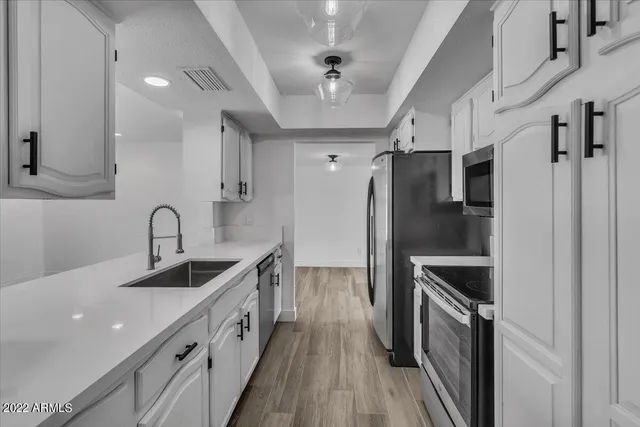 a kitchen with stainless steel appliances granite countertop a refrigerator and a sink