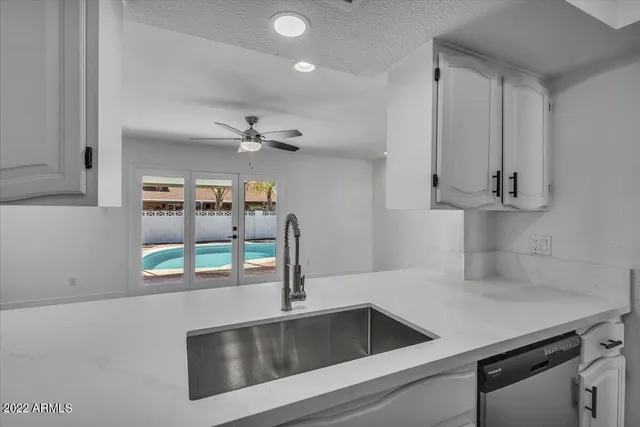 a kitchen with stainless steel appliances granite countertop a sink and a refrigerator
