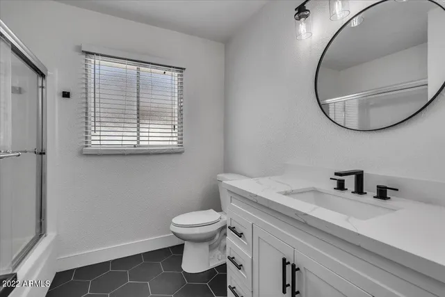 a bathroom with a sink a toilet and a mirror