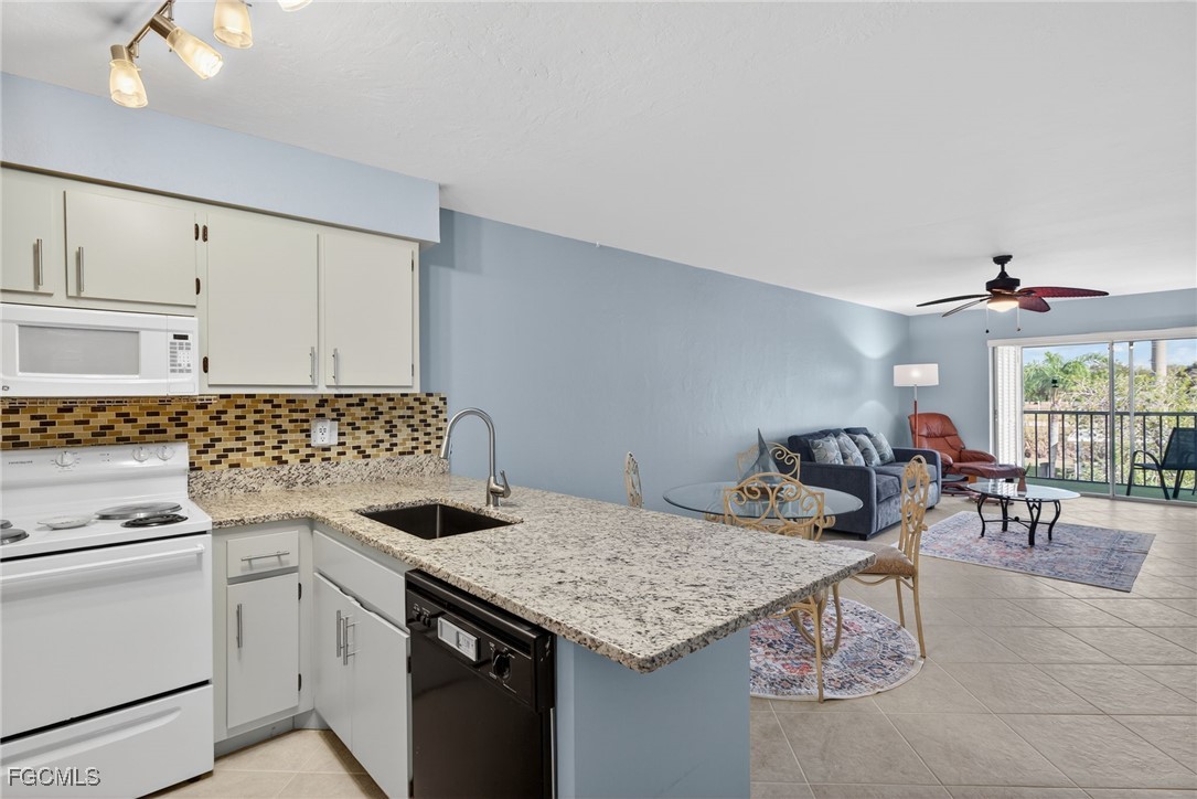 1100 Pondella Road, Unit 811 Cape Coral, FL 33909 - Photo 4 of 24 a kitchen with granite countertop a sink stove and cabinets