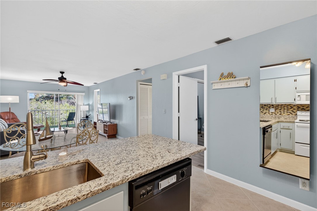 1100 Pondella Road, Unit 811 Cape Coral, FL 33909 - Photo 5 of 24 a kitchen with stainless steel appliances granite countertop a sink stove and refrigerator