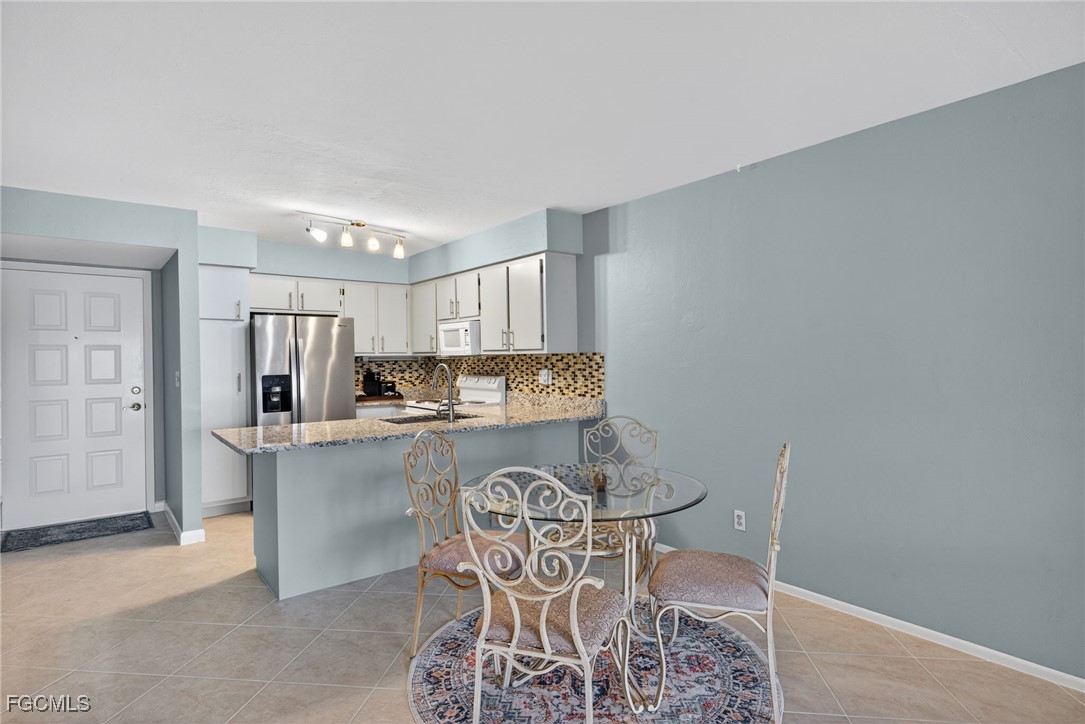 1100 Pondella Road, Unit 811 Cape Coral, FL 33909 - Photo 6 of 24 a view of a dining room with furniture and chandelier