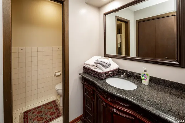 a bathroom with a granite countertop sink and a mirror