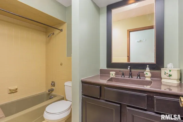 a bathroom with a sink toilet vanity and shower