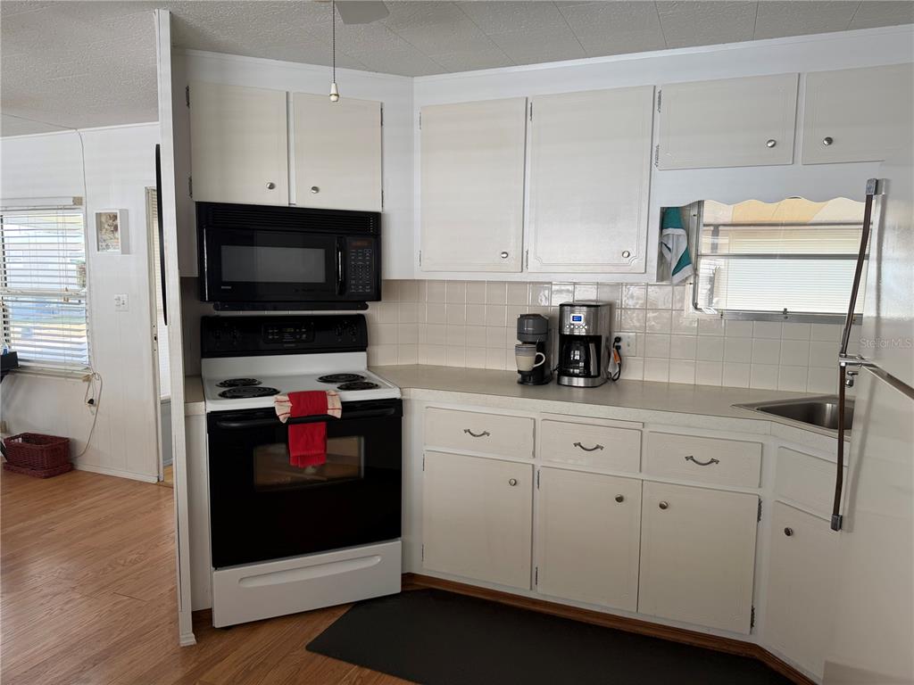 1040 Main Street, Unit 91 Dunedin, FL 34698 - Photo 15 of 25 a kitchen with stainless steel appliances granite countertop white cabinets and a stove