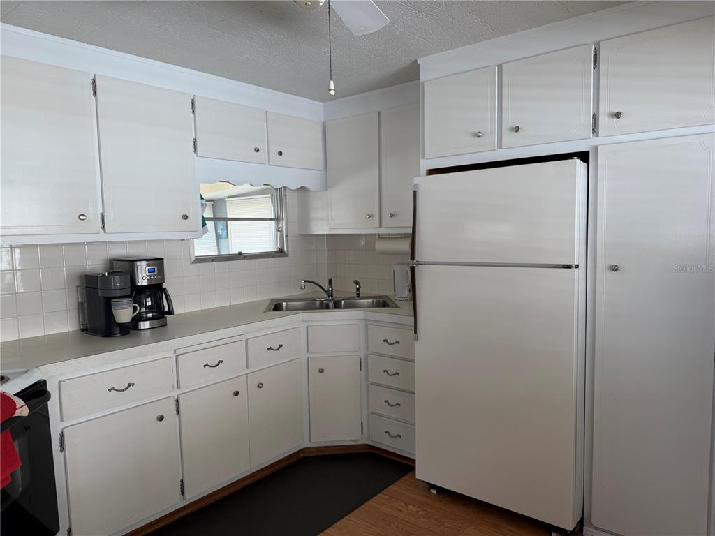 1040 Main Street, Unit 91 Dunedin, FL 34698 - Photo 16 of 25 a kitchen with refrigerator cabinets and a sink