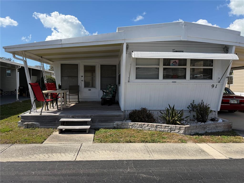 1040 Main Street, Unit 91 Dunedin, FL 34698 - Photo 2 of 25 a front view of a house with porch and dining space