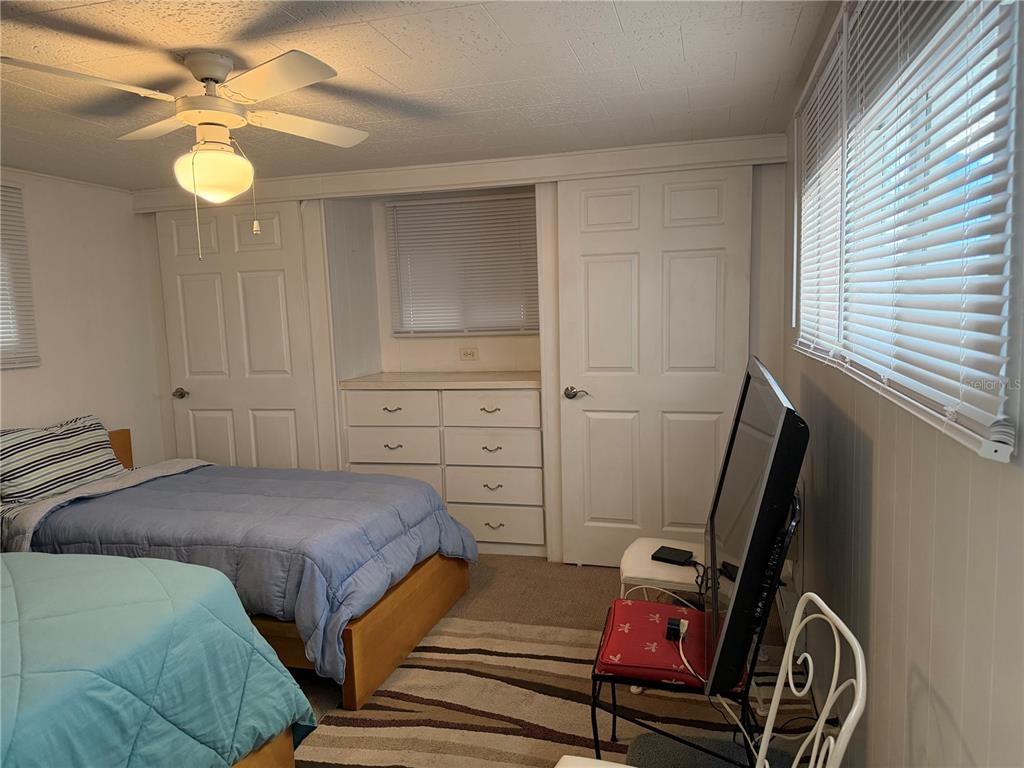 1040 Main Street, Unit 91 Dunedin, FL 34698 - Photo 21 of 25 a bedroom with a bed and a chandelier