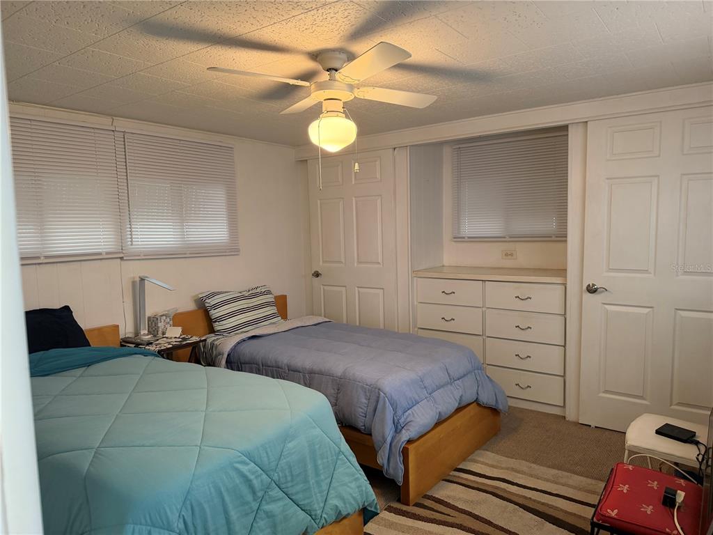 1040 Main Street, Unit 91 Dunedin, FL 34698 - Photo 22 of 25 a bedroom with two beds and a chandelier