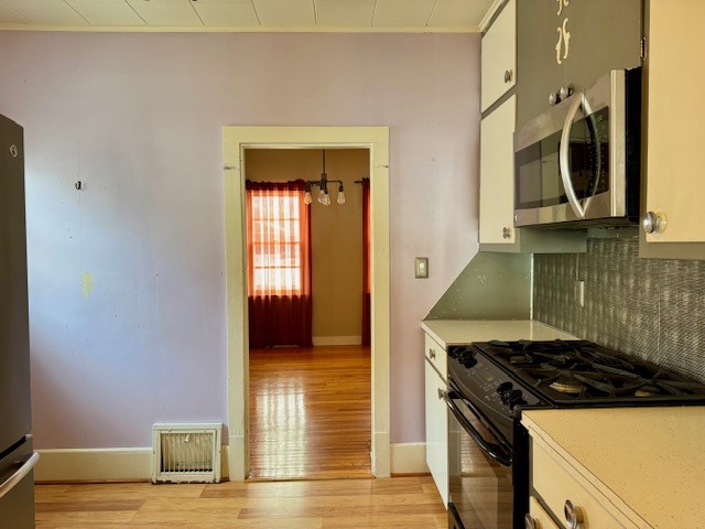 2918 Pershing Boulevard Clinton, IA 52732 - Photo 5 of 33 a kitchen with granite countertop a stove and a wooden floor