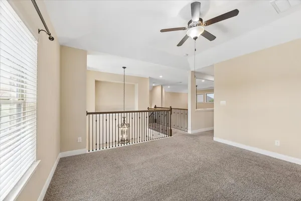 a view of a big room with windows and ceiling fan
