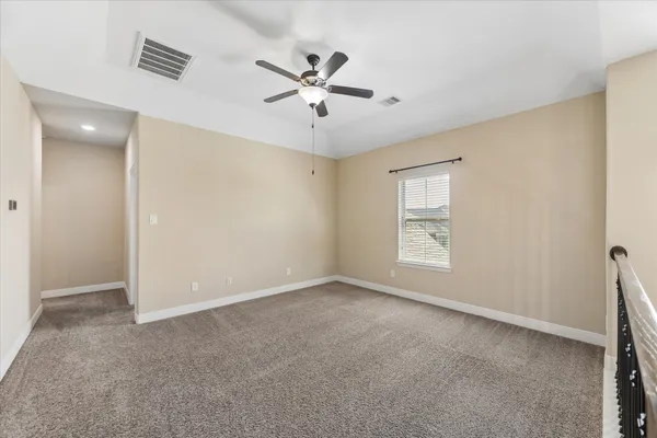 an empty room with fan and windows