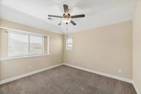 an empty room with a window and a fan