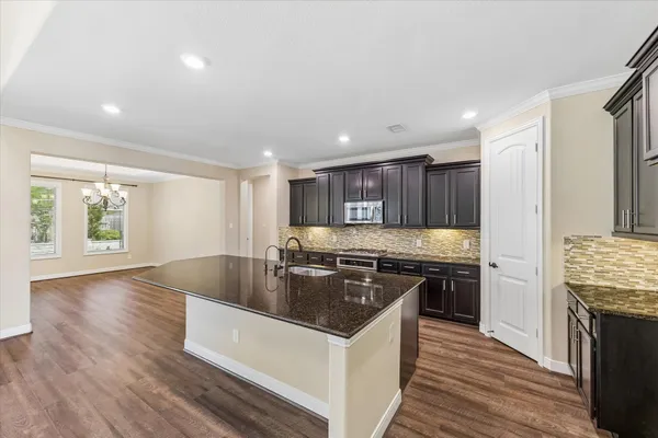 a kitchen with granite countertop lots of counter top space a sink and stainless steel appliances